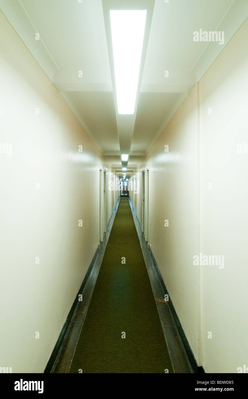 L'éclairage fluorescent artificielle à long couloir vide en bloc d'appartements, Londres, Angleterre, Grande-Bretagne, Royaume-Uni Banque D'Images