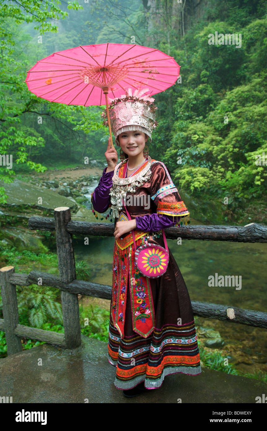 Jolie jeune fille en costume Tujia formelle tenant un parapluie rose pour les photos du parc national pittoresque Wulingyuan Province du Hunan, Chine Banque D'Images