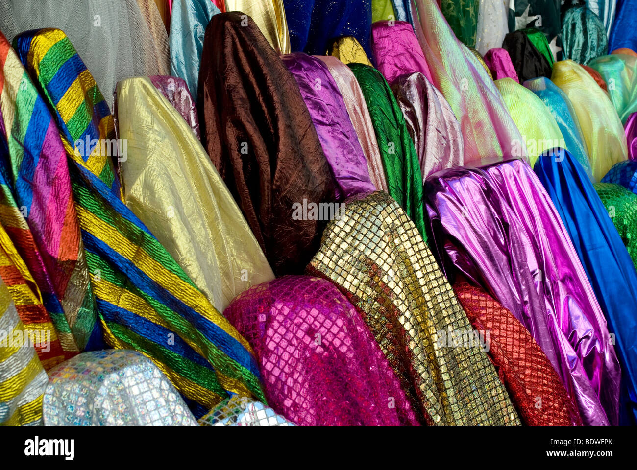 Des tissus de couleurs exotiques en vente dans une boutique de tabliers dans la rue de marche du marché Saint Pierre, Montmartre, Paris. Banque D'Images