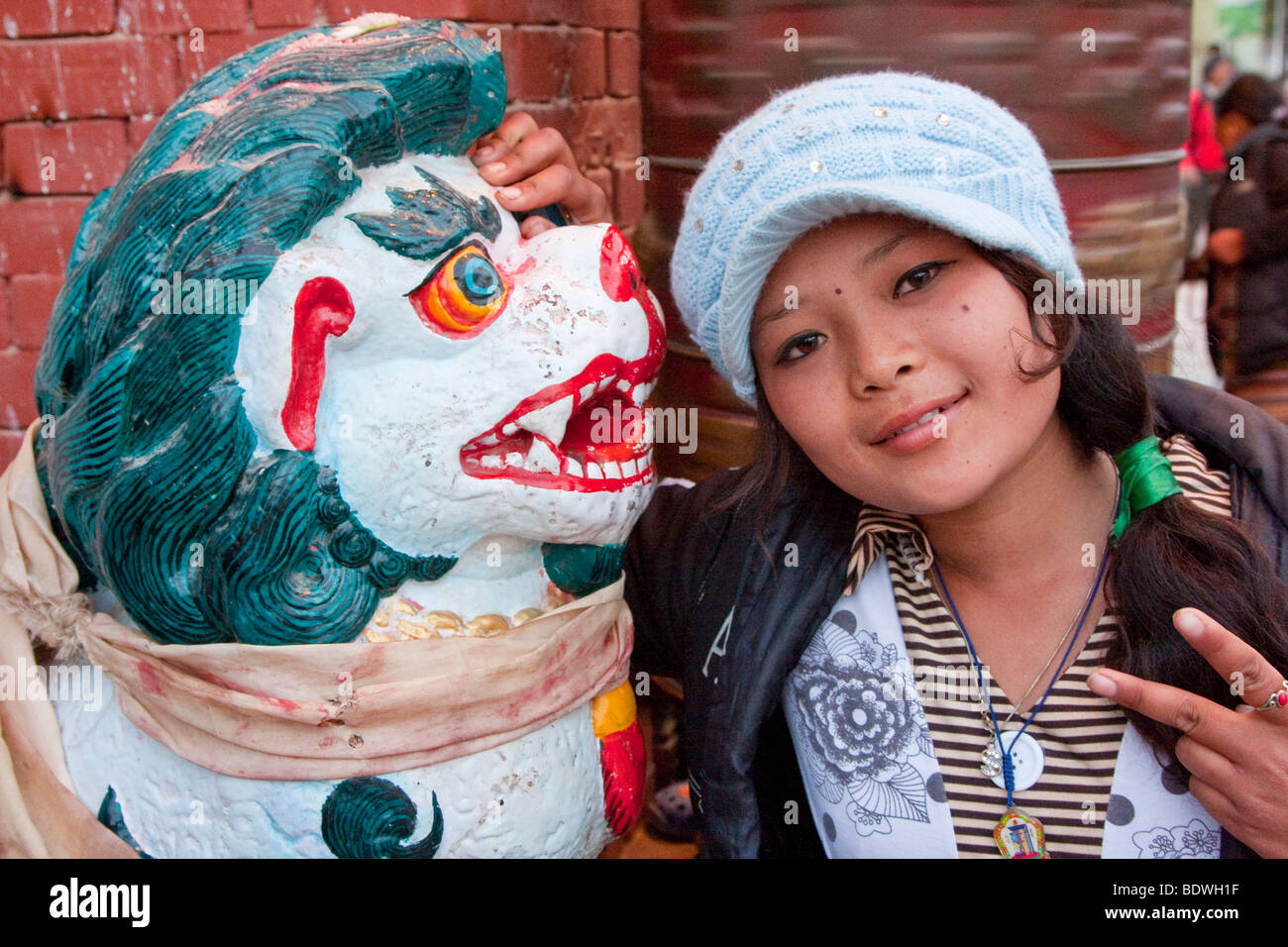 Bodhnath, au Népal. Jeune femme à côté népalais Snow Leopard mythique à l'entrée du sanctuaire bouddhiste. Banque D'Images