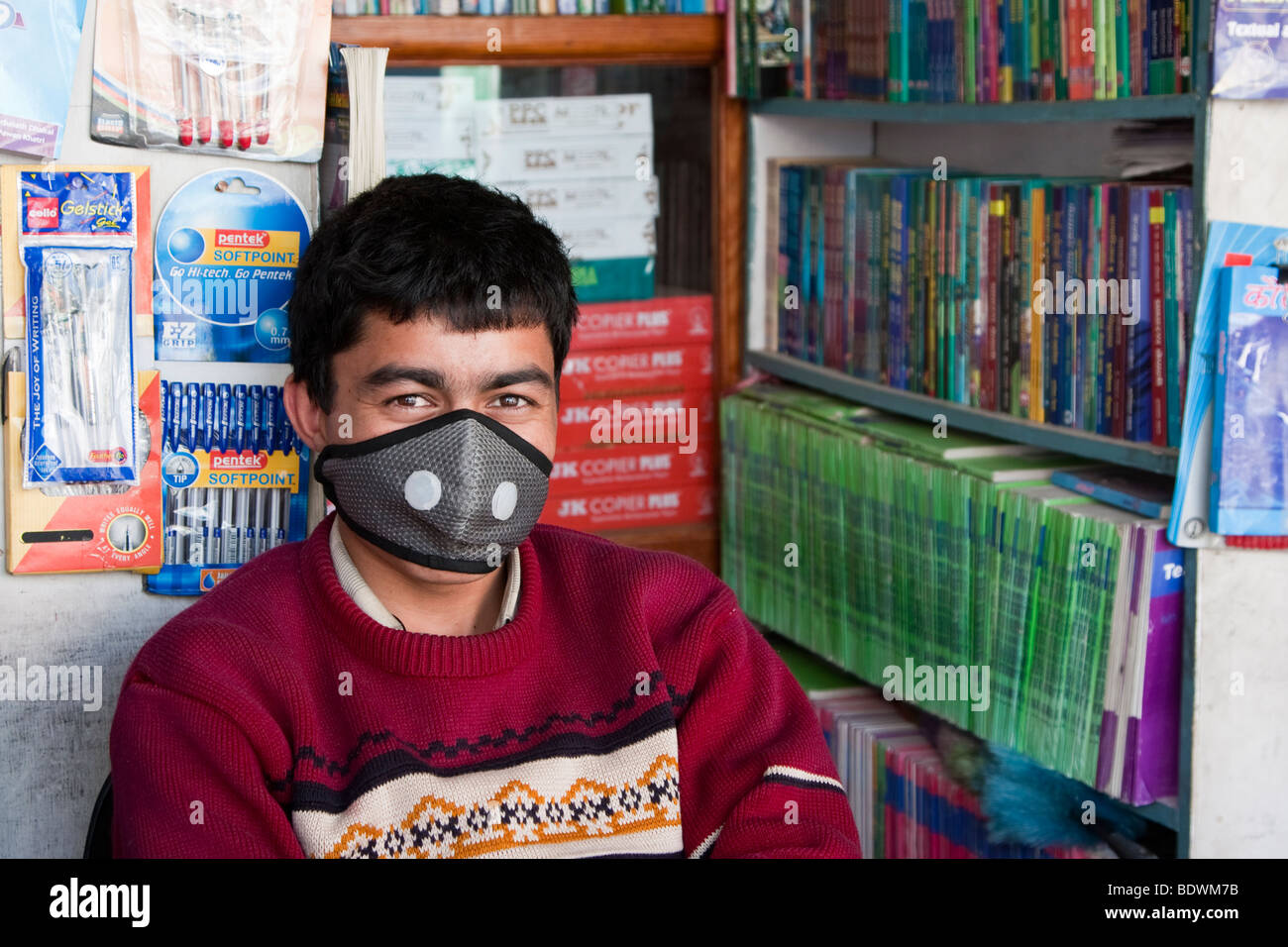 Katmandou, Népal. Vendeur magasin de livre népalais, le port de masque respiratoire de protection contre la pollution de l'air. Banque D'Images