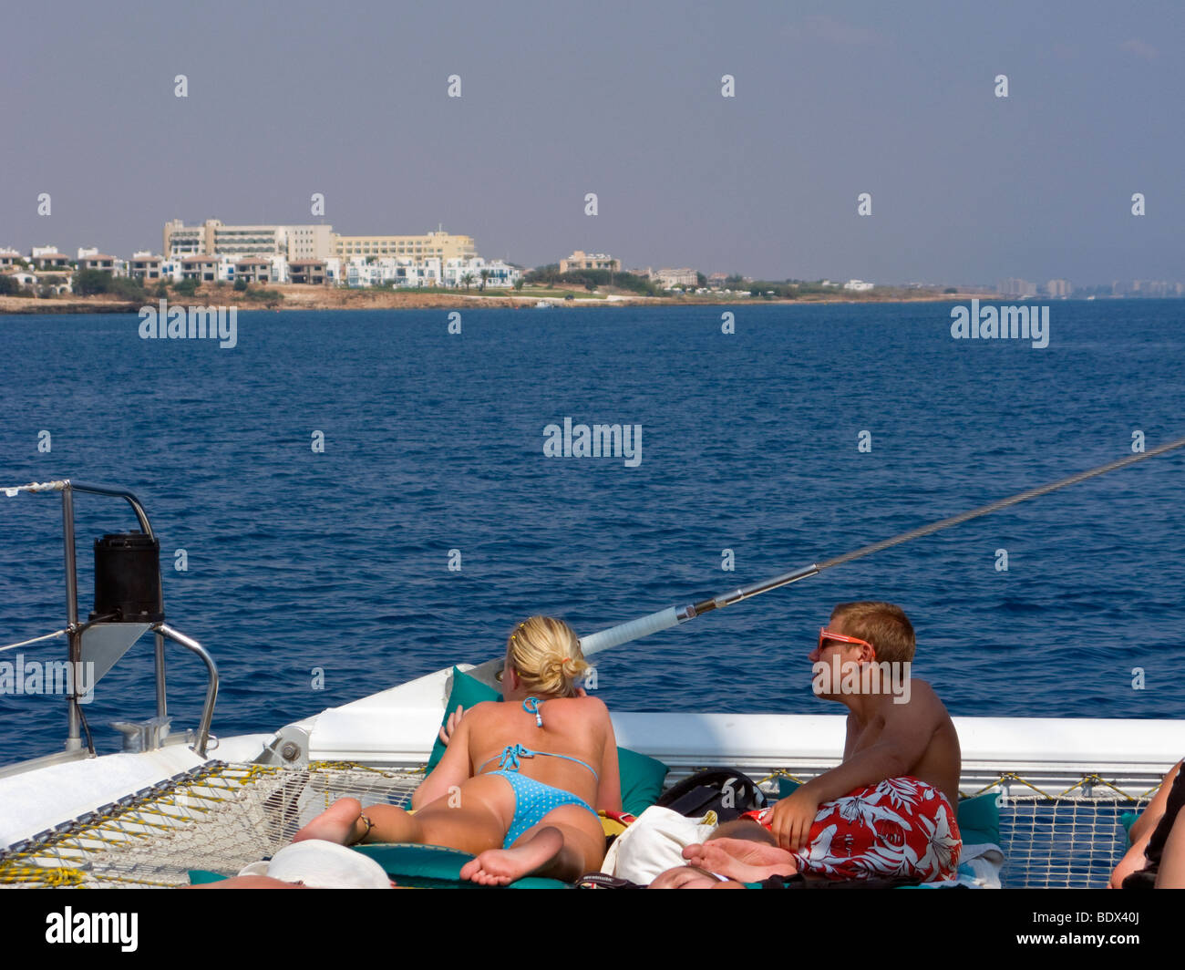 Les touristes sur un catamaran à la recherche sur la plage. Dans l'extrême droite de la photo vous pouvez voir la ville fantôme de Famagouste. Chypre. Banque D'Images