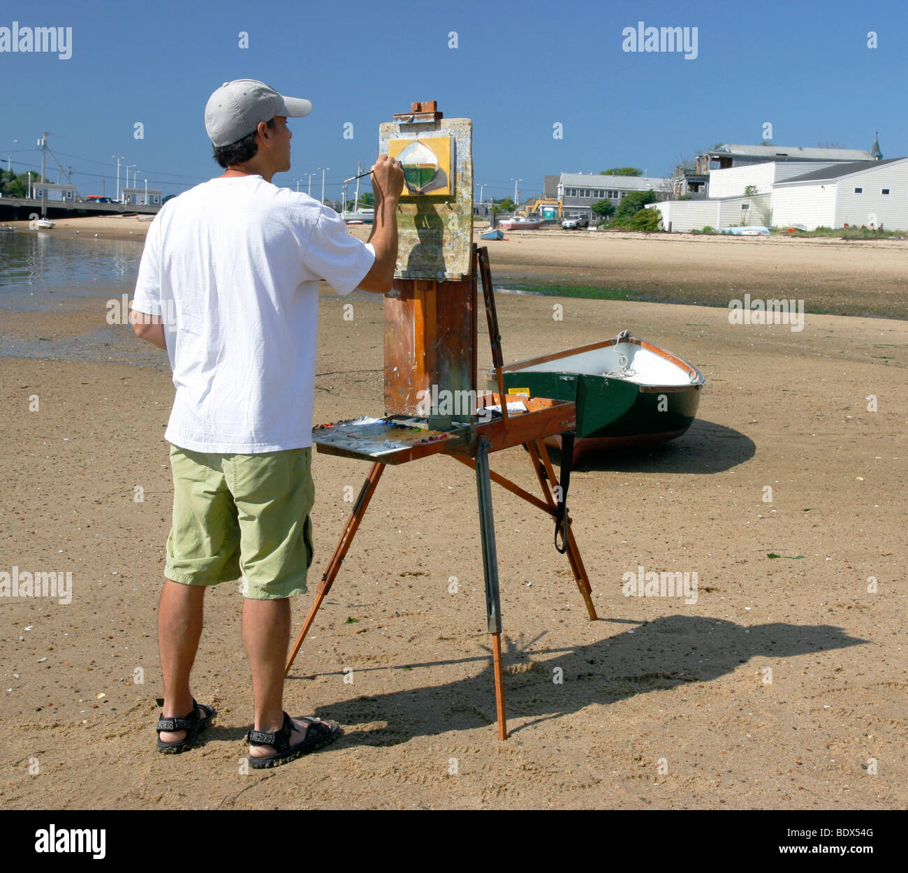 La peinture de l'artiste masculin un bateau sur la plage à Provincetown, Massachusetts. Banque D'Images