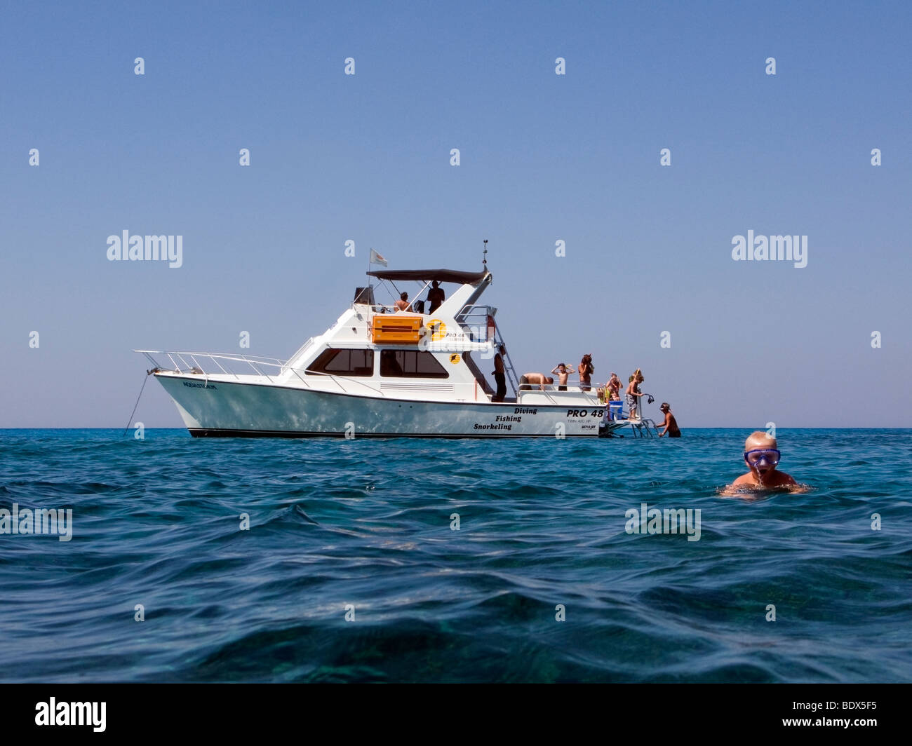 Jeune garçon à l'avant du bateau avec les touristes en apnée d'Ayia Napa, à Chypre, les grottes marines Banque D'Images