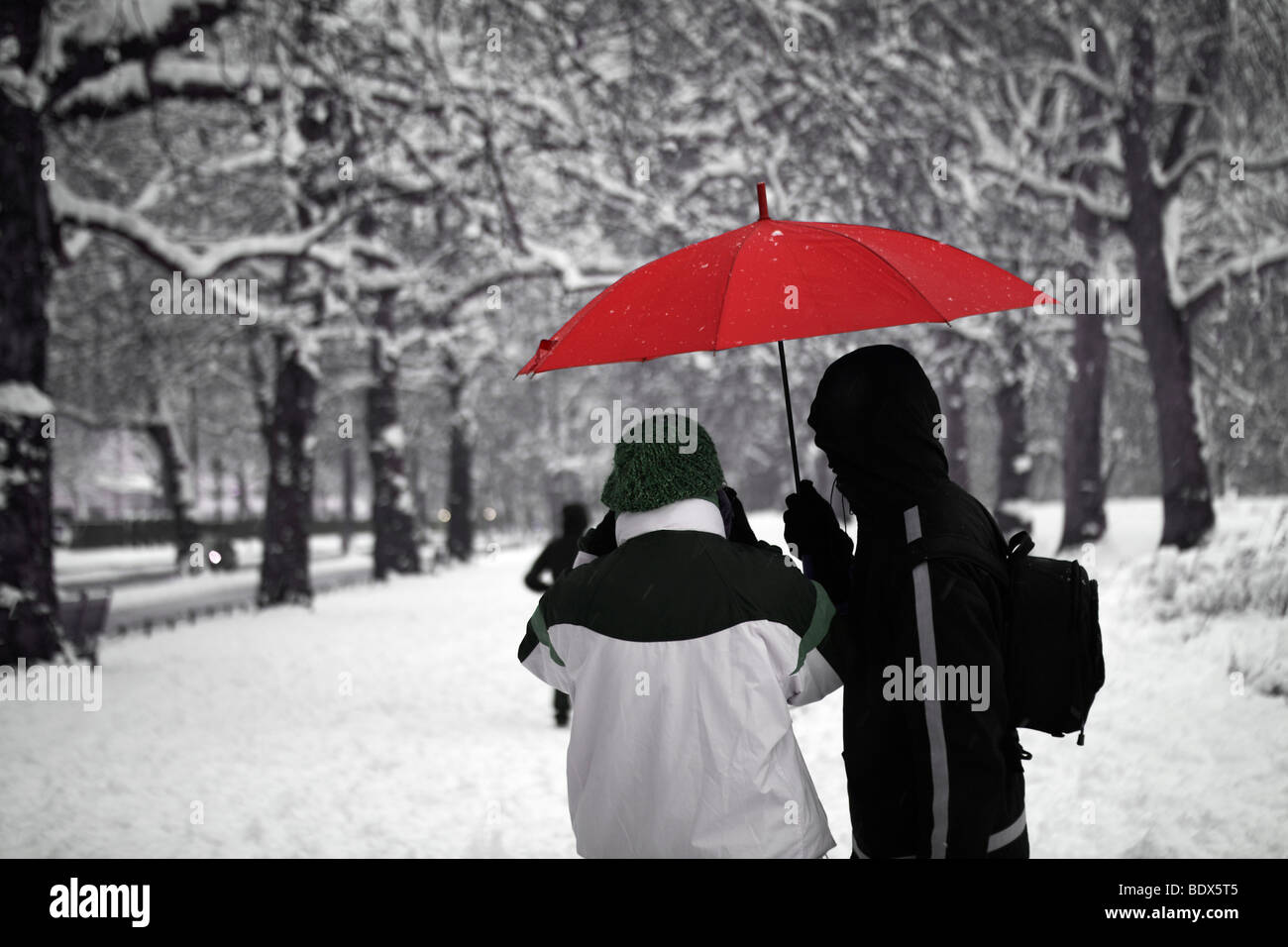Londres : NEIGE COUPLE AVEC parapluie rouge Banque D'Images