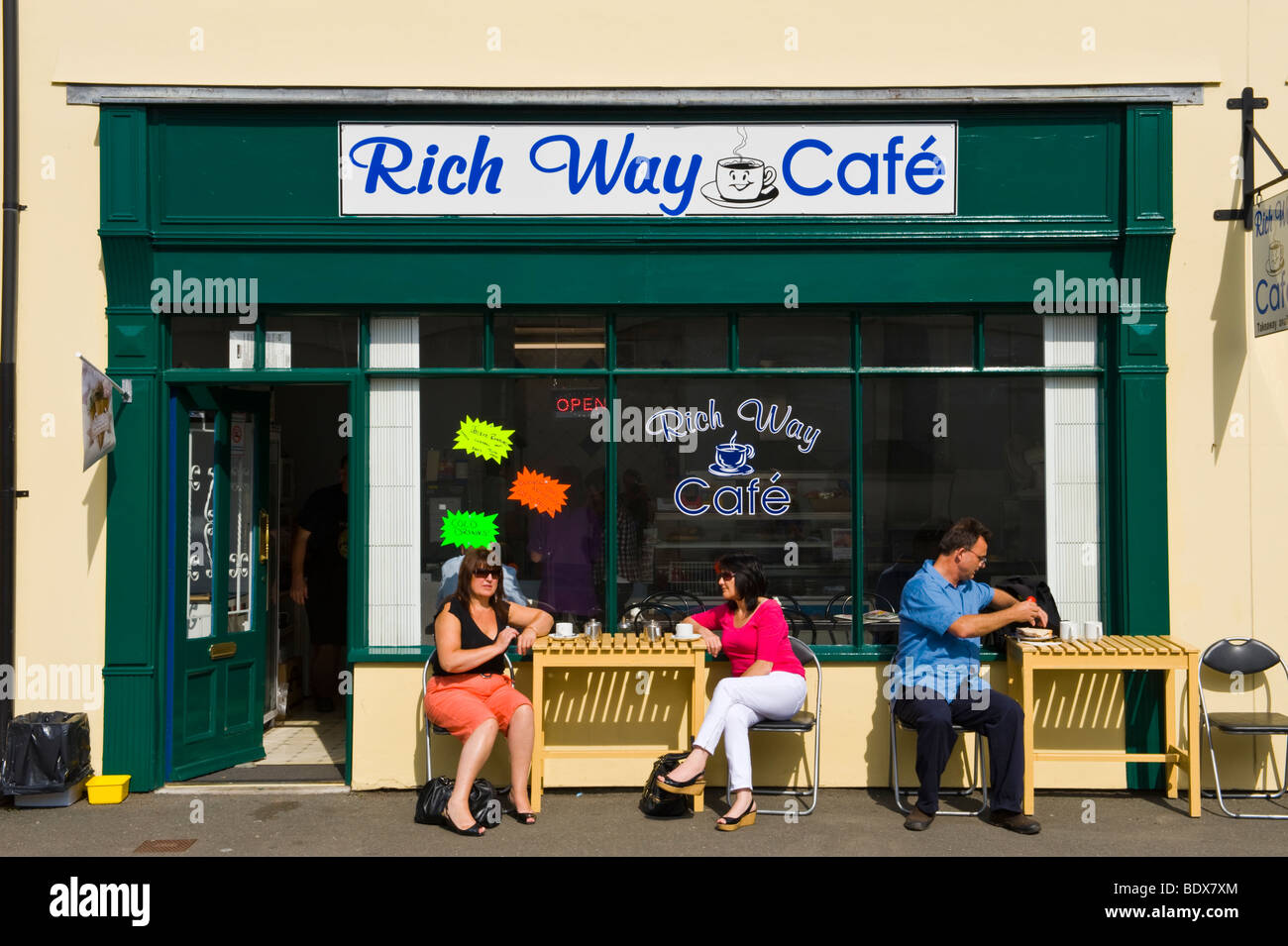 Les gens assis à des tables à l'extérieur riche cafe à Brecon Powys Pays de Galles UK Banque D'Images
