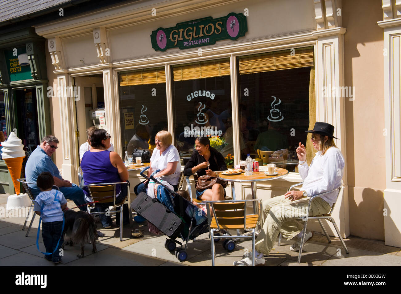 Les gens assis à des tables à l'extérieur restaurant Giglios à Brecon Powys Pays de Galles UK Banque D'Images