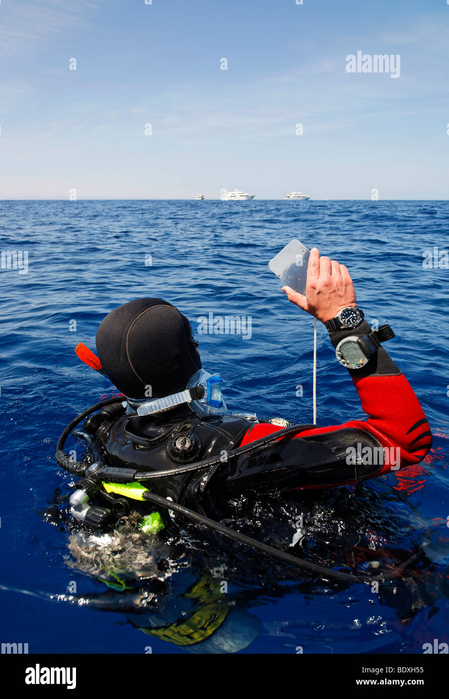 Plongeur à la dérive en mer tente d'obtenir l'attention des gens sur les bateaux de plongée sur l'horizon par un clignotement à l'aide d'un miroir, l'Égypte, R Banque D'Images