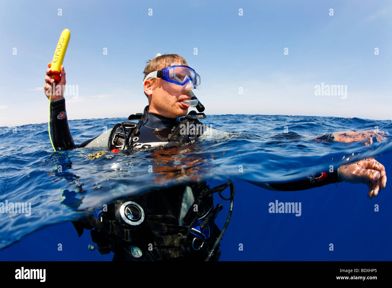 Plongeur à la dérive en mer la tenue d'un émetteur ENOS, une alarme d'urgence électronique et système de repérage, au-dessus du niveau de l'eau, so Banque D'Images