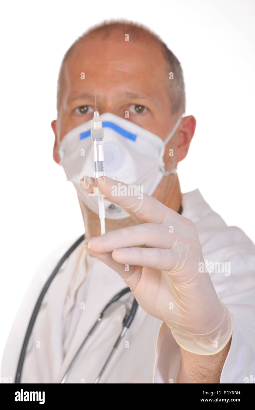 Médecin portant un masque anti-virus, holding a syringe Banque D'Images