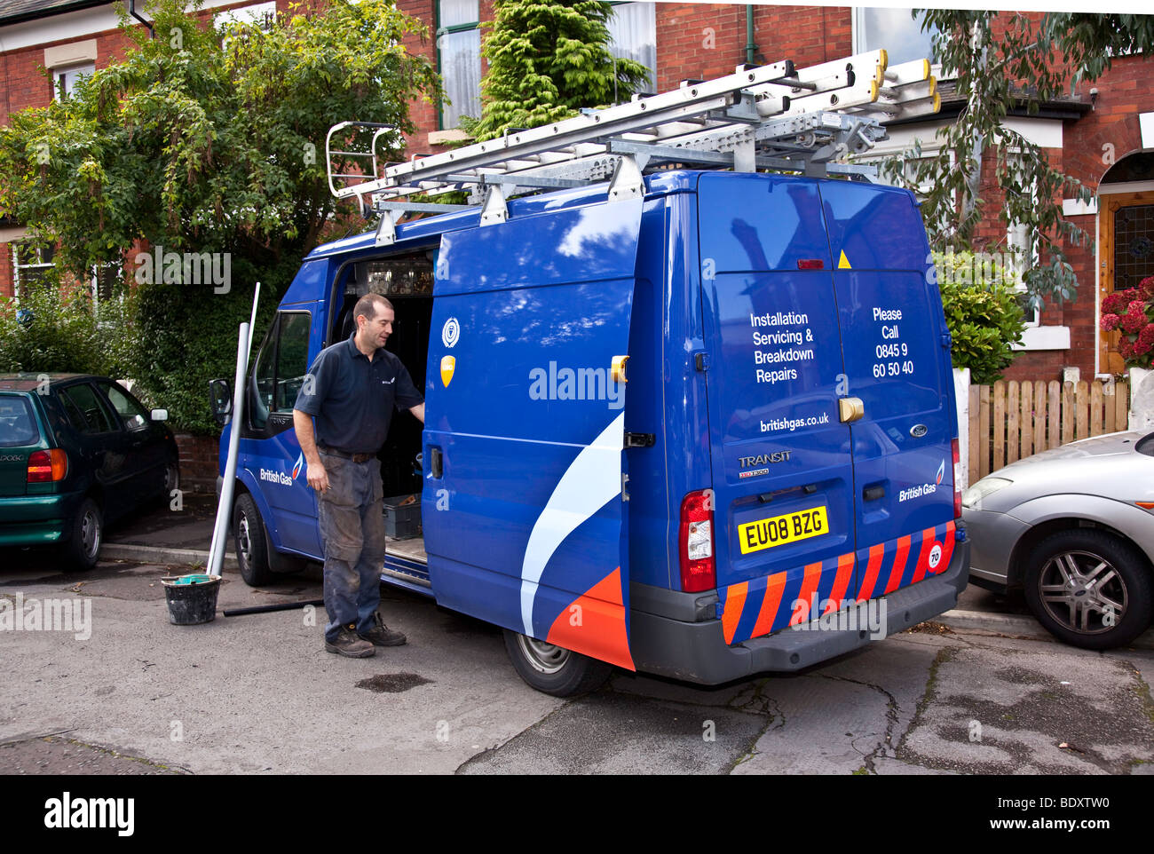 British Gas fitter lors du remplacement d'une vieille chaudière inefficace avec une nouvelle chaudière condenseur efficace. Banque D'Images