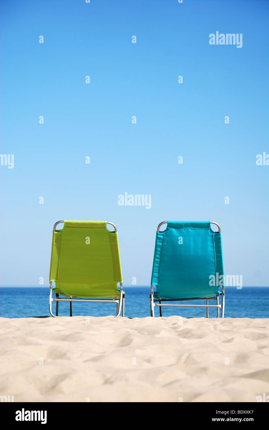 Deux chaises longues sur une plage à côté de l'autre Banque D'Images
