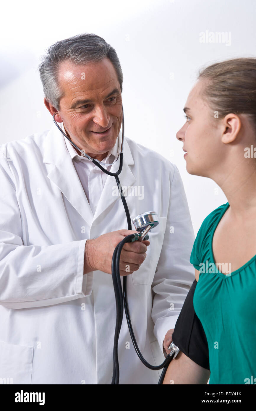 Doctor la pression sanguine d'un jeune patient Banque D'Images
