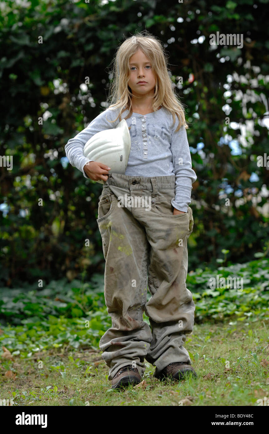 Petite fille de 7 ans habillé en vêtements de travail avec un