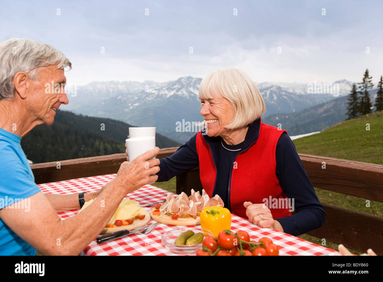 Senior couple eating in mountains Banque D'Images