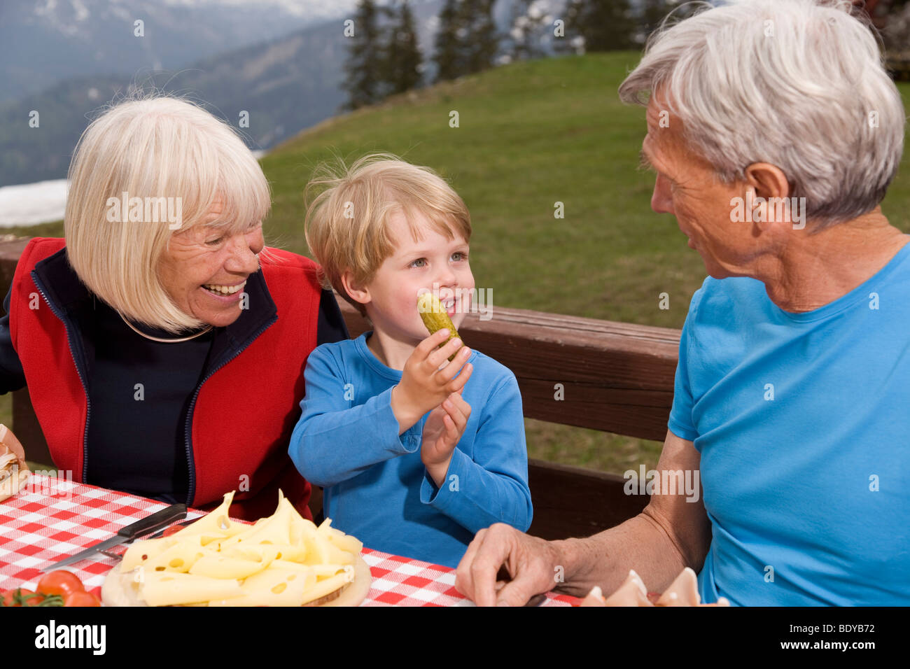 Couple et petit-fils de manger dans les montagnes Banque D'Images