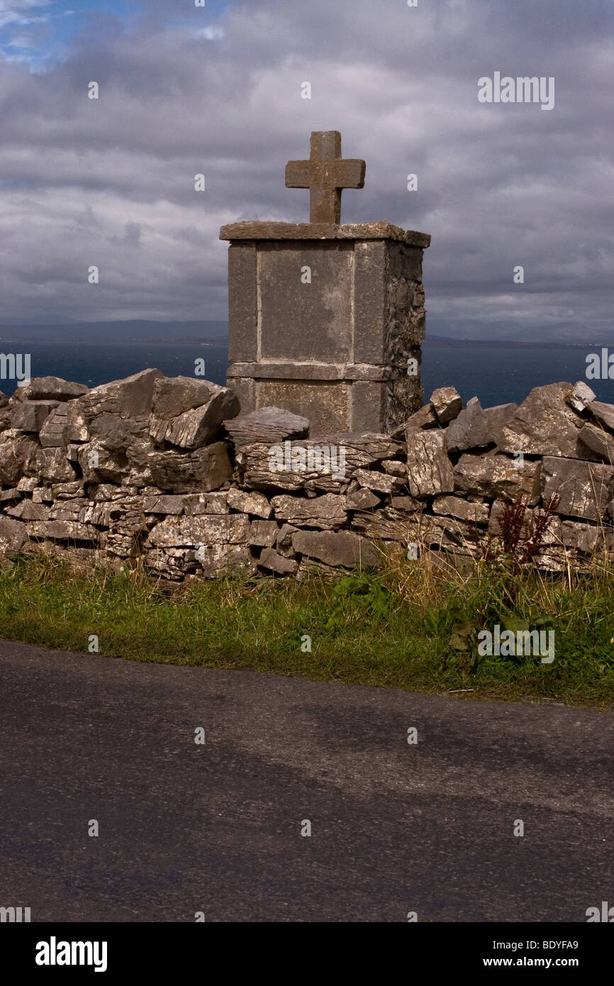 Pierre tombale traditionnelle vu sur un mur de pierre, l'Inis Mor (Inismore) Island, les îles d'Aran, Co. de Galway, Irlande Banque D'Images