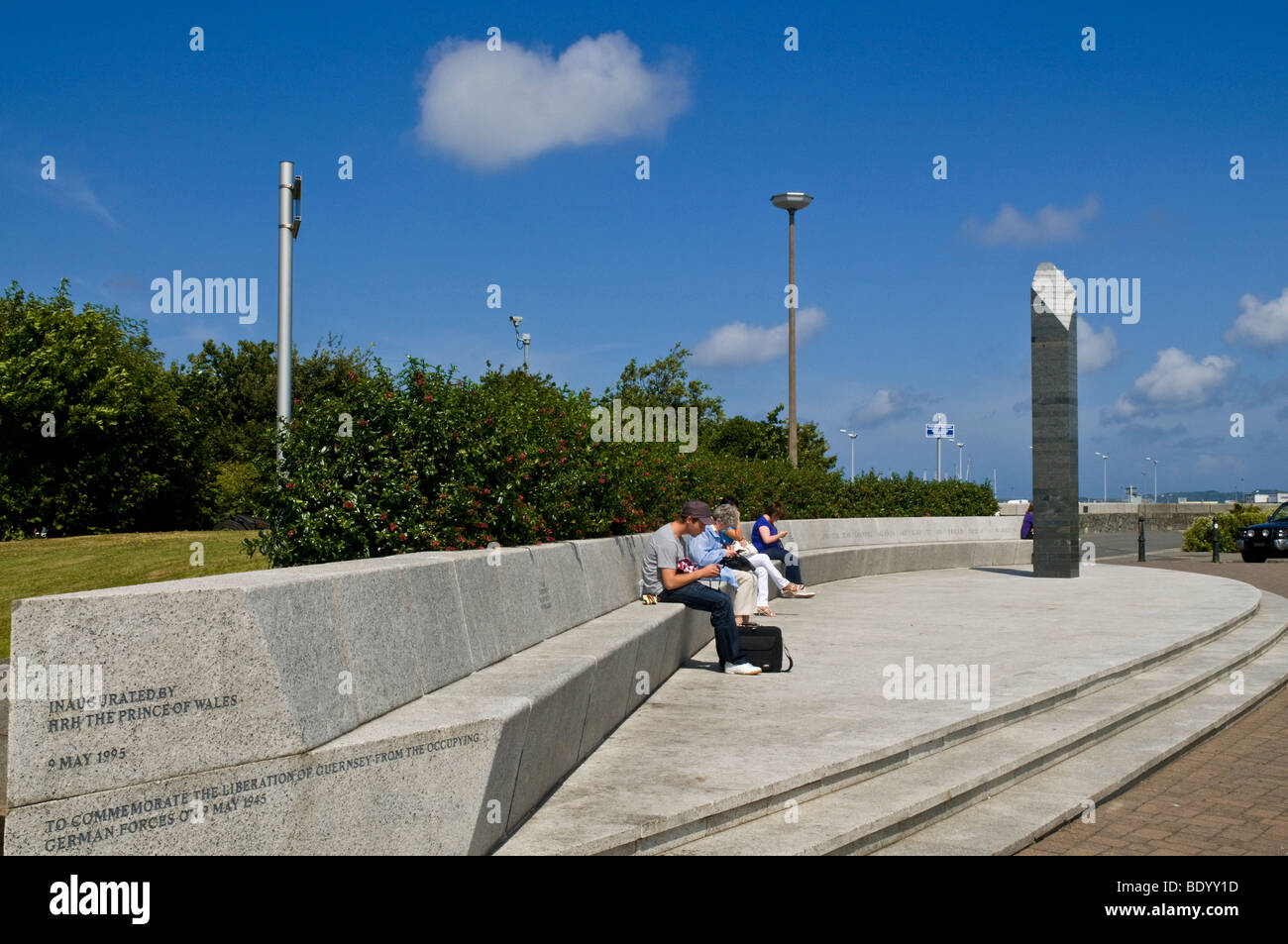 dh Mémorial d'occupation ST PETER PORT GUERNESEY personnes se détendant sur des sièges au monument de libération du quai St Julians canal de la guerre des îles Banque D'Images
