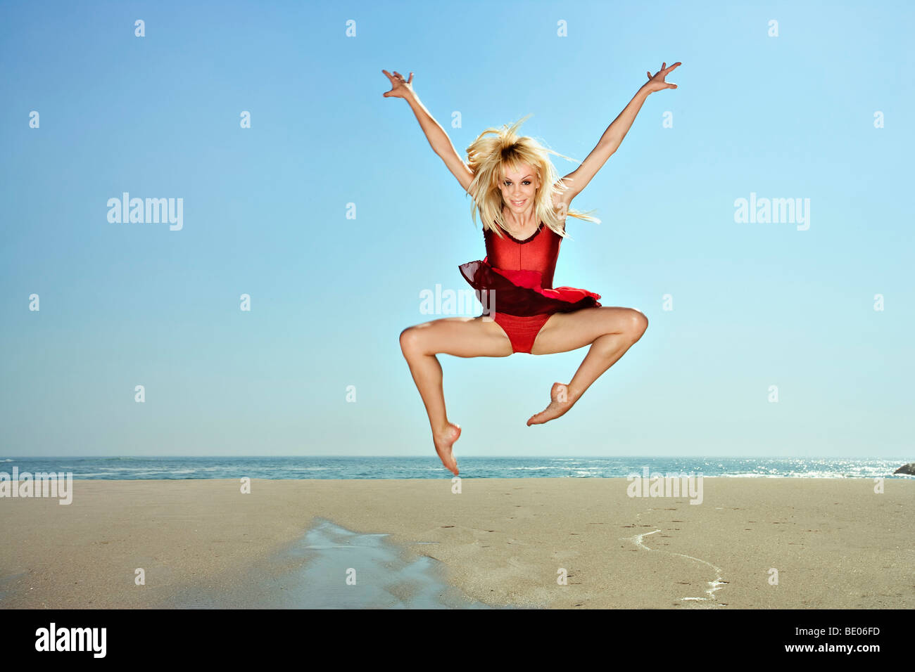 Les jeunes femmes sautant sur une plage Banque D'Images