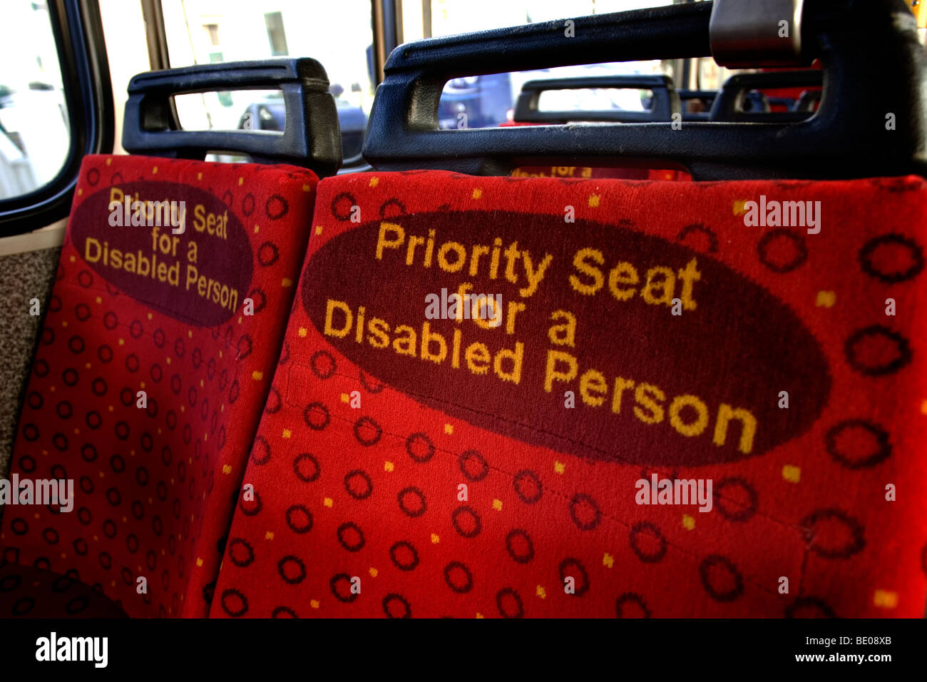 Rouge lumineux sièges prioritaires pour les personnes handicapées sur un bus à Brighton, East Sussex, UK. Banque D'Images