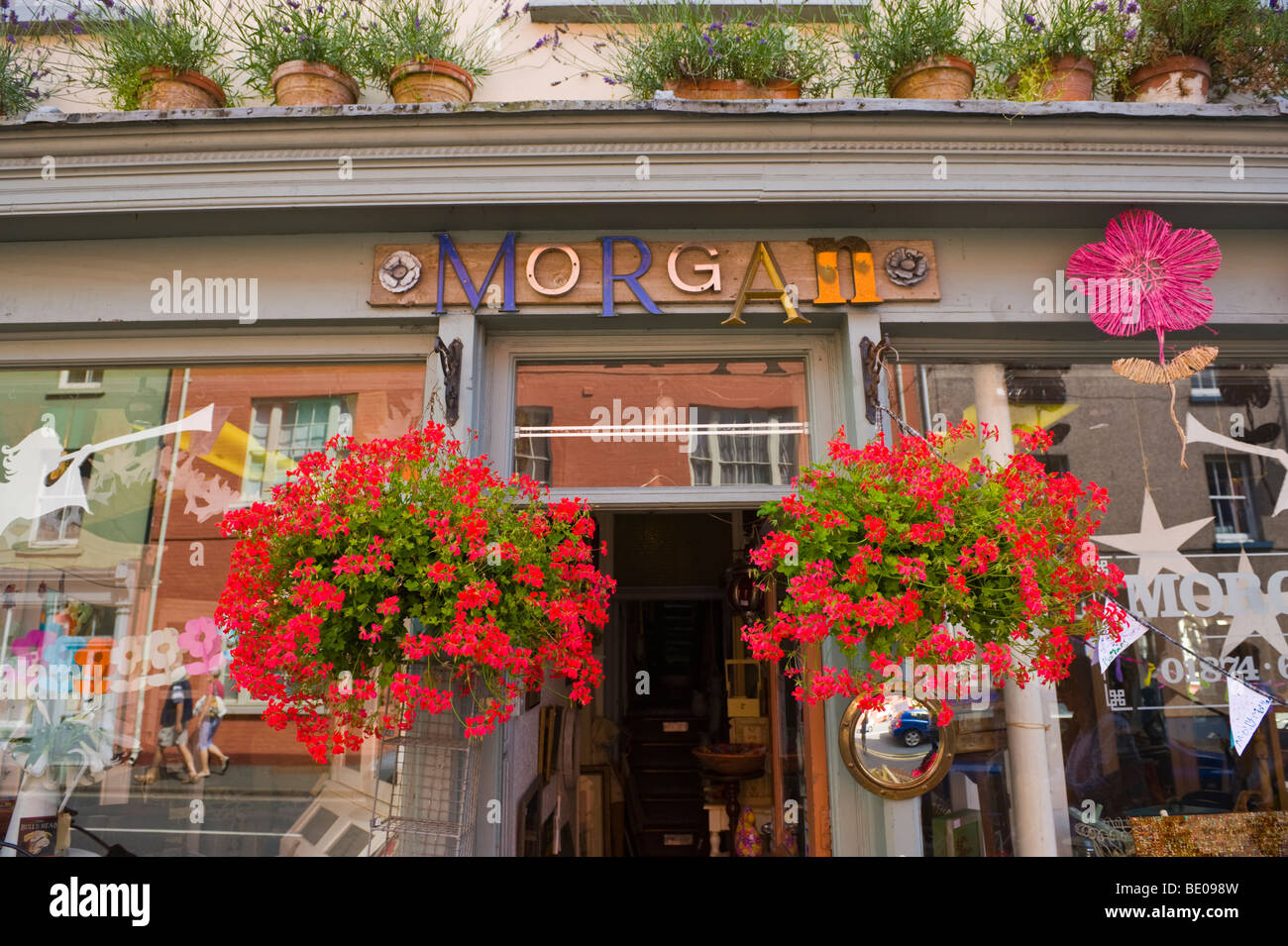 Extérieur de bric-à-brac shop de paniers de fleurs suspendus à l'extérieur à Brecon Powys Pays de Galles UK Banque D'Images