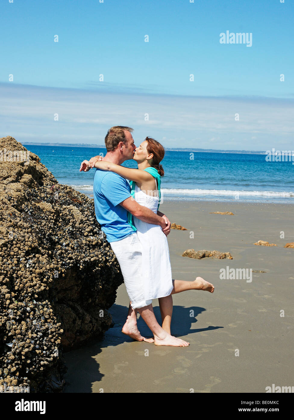 Un Couple Amoureux Appuyé Contre Un Rocher Sur La Plage Et