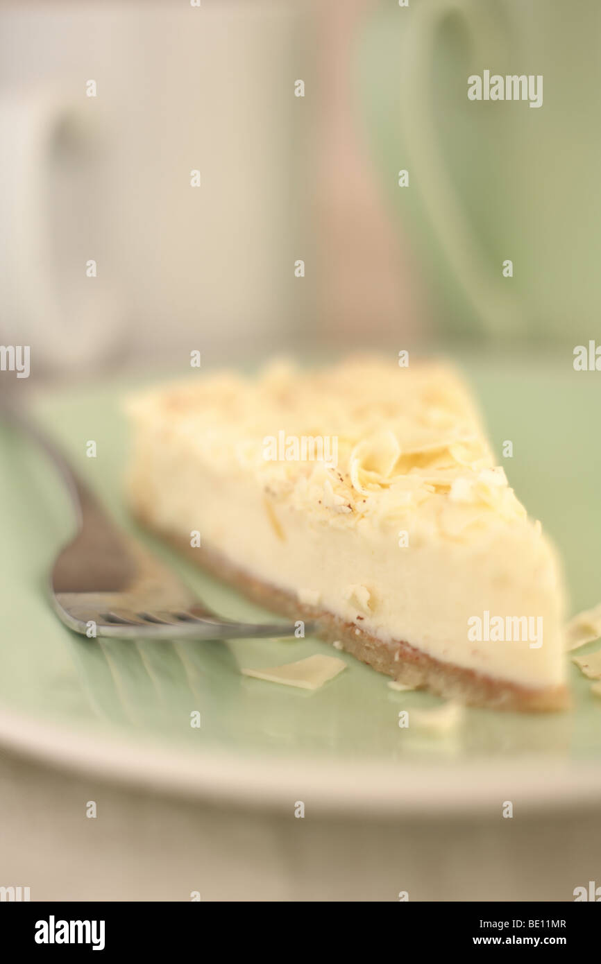 Un morceau de gâteau au fromage sur une assiette avec une fourchette Banque D'Images