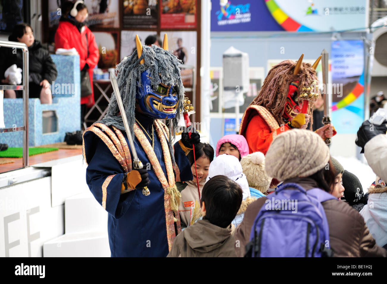 Deux Japonais Oni (démons, diables) séance enfants à la Sapporo Snow Festival. Banque D'Images