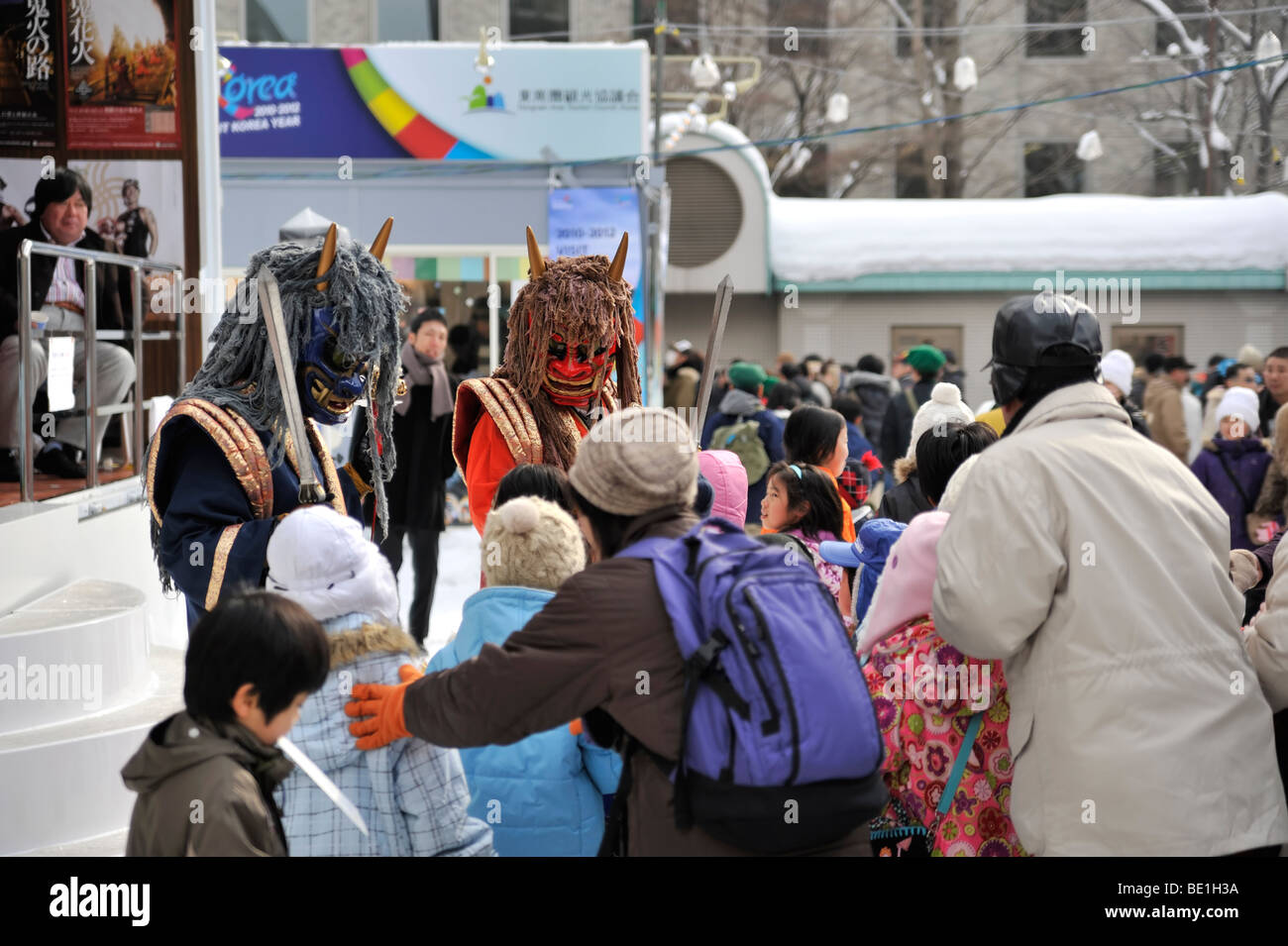 Deux Japonais Oni (démons, diables) séance enfants à la Sapporo Snow Festival. Banque D'Images