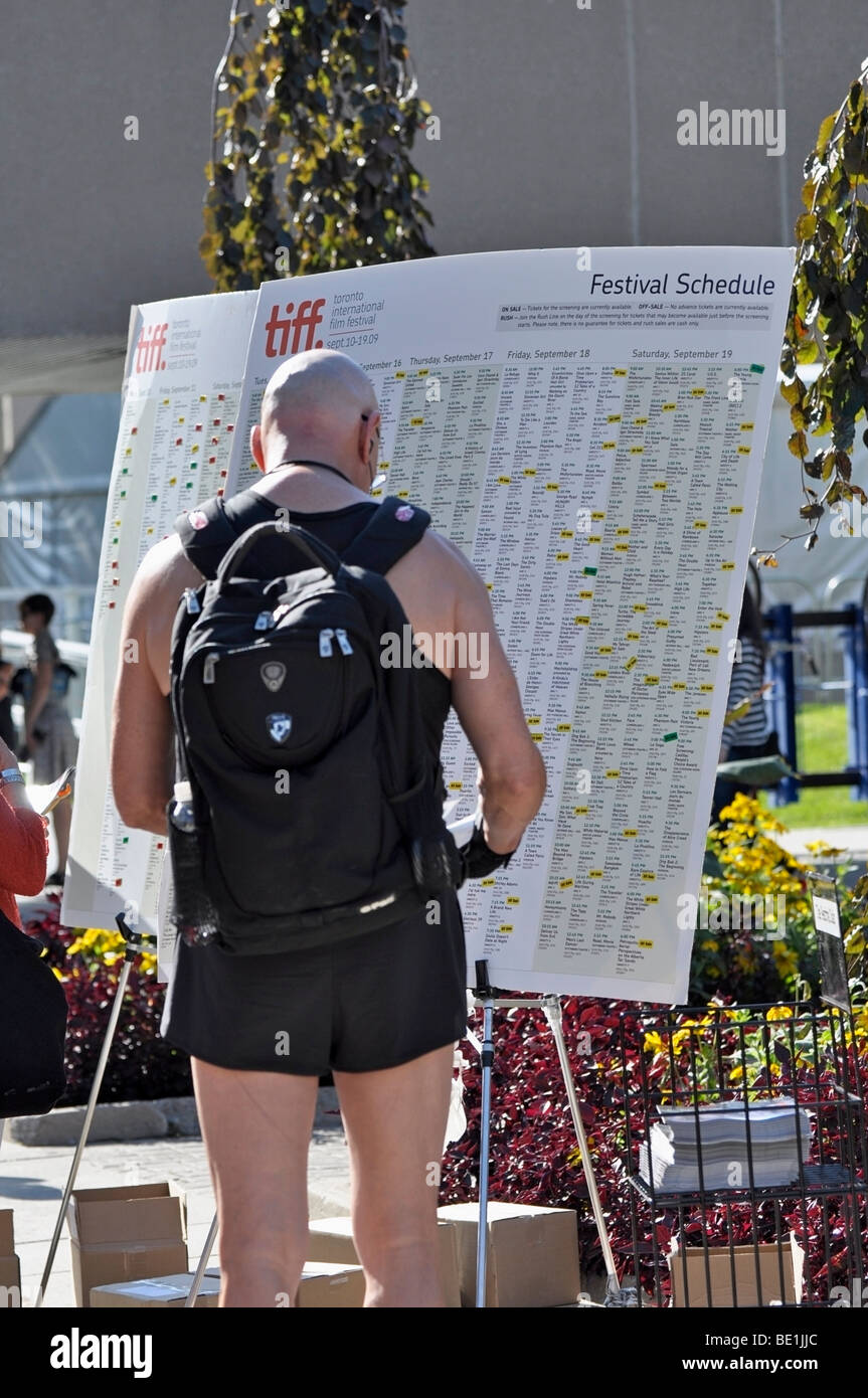 Les gens, les passants en étudiant le TIFF (Toronto International Film Festival les horaires) Banque D'Images