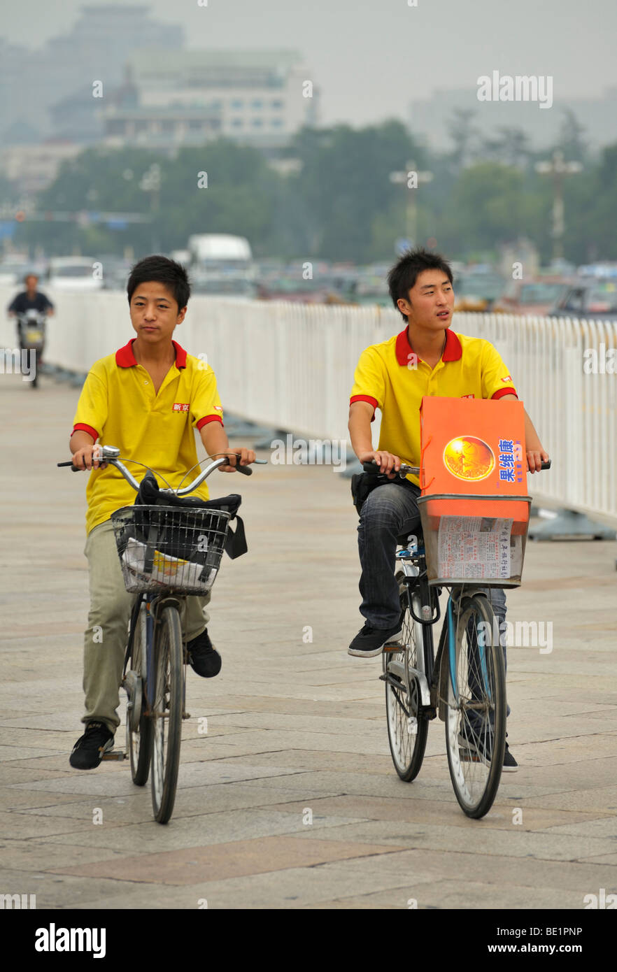 Deux jeunes garçons à vélo le long de la place Tiananmen, Pékin CN Banque D'Images