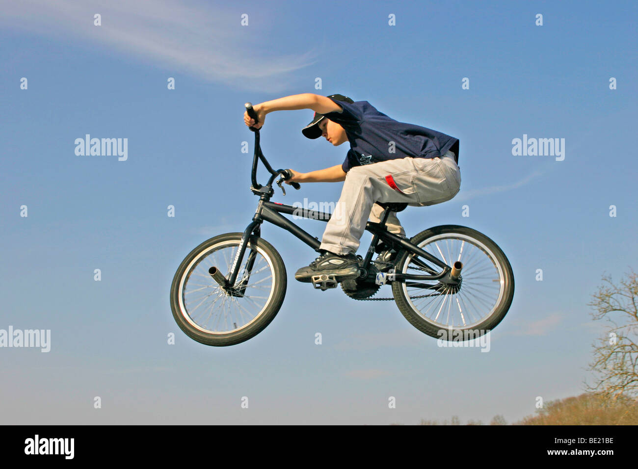Jeune garçon sautant avec son vélo Banque D'Images