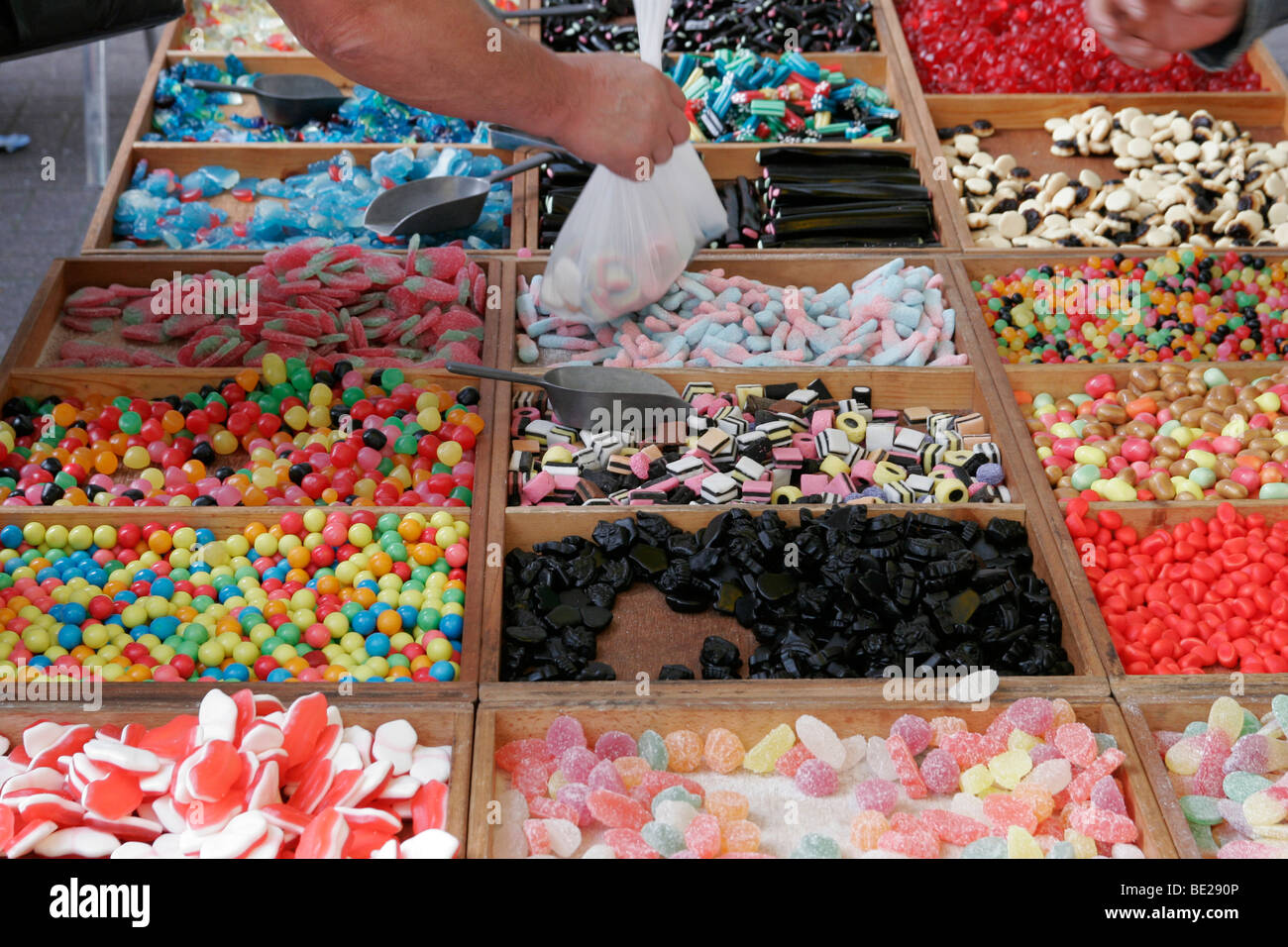 Choisir et mélanger les sucreries dans les bacs sur une échoppe de marché, Lille, France Banque D'Images
