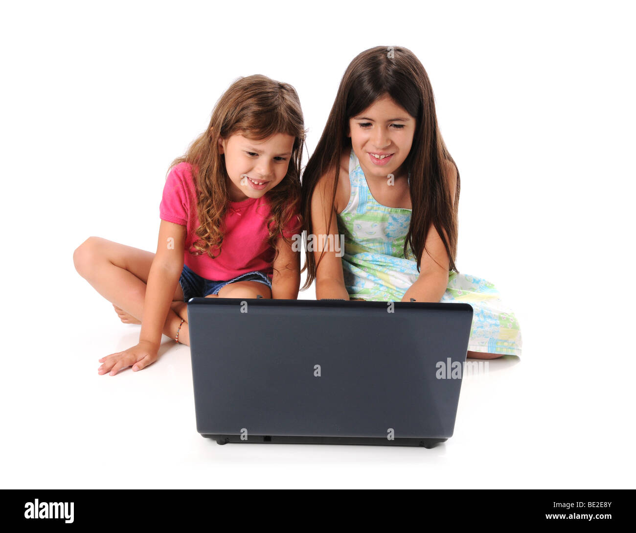 Les jeunes filles à l'aide d'un ordinateur portable isolé sur fond blanc Banque D'Images