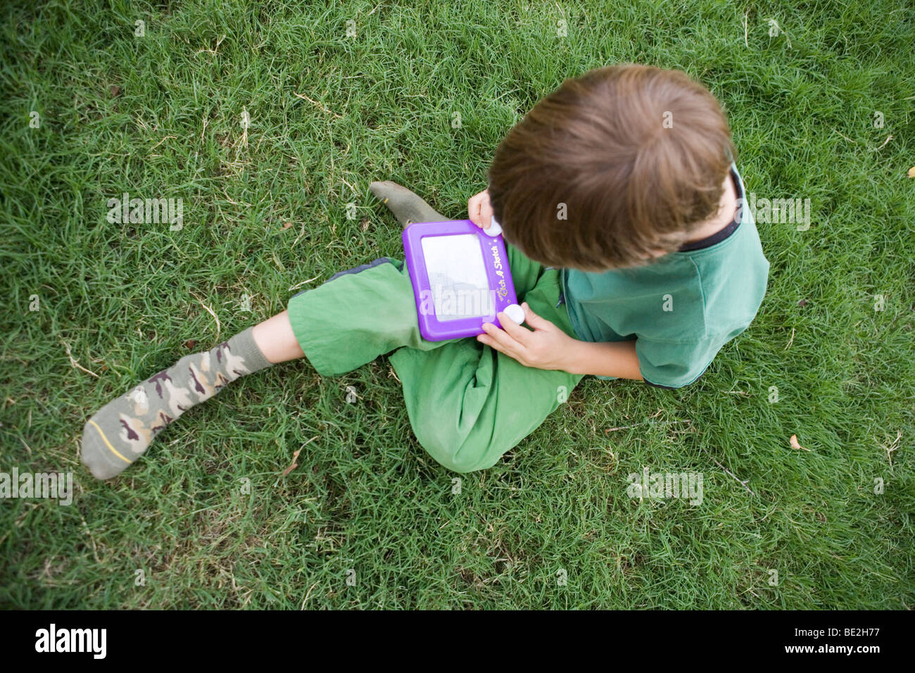 Sept ans de faire un dessin avec un etch-a-sketch toy Banque D'Images