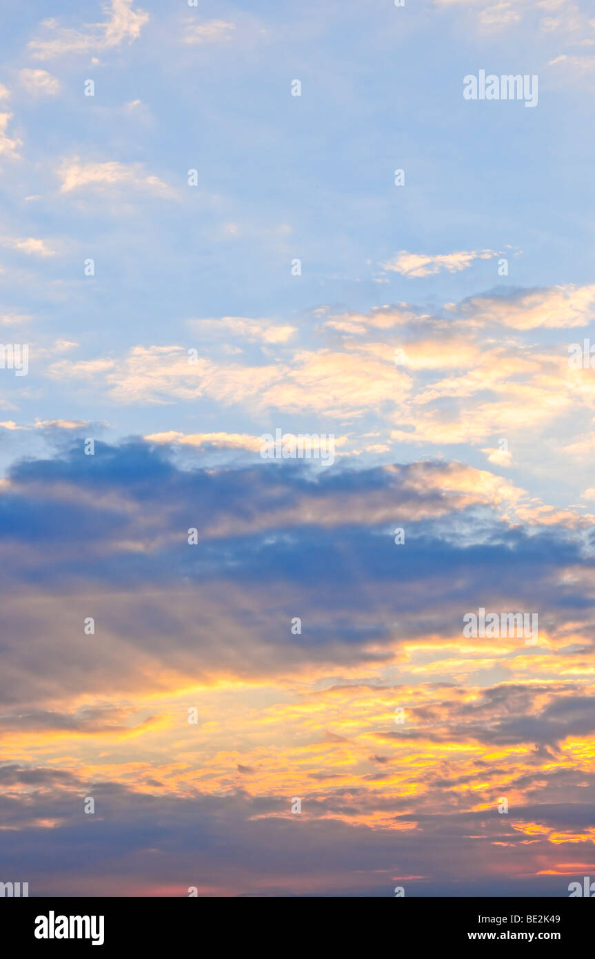 Ciel bleu au coucher du soleil avec des rayons du soleil et nuages lumineux Banque D'Images