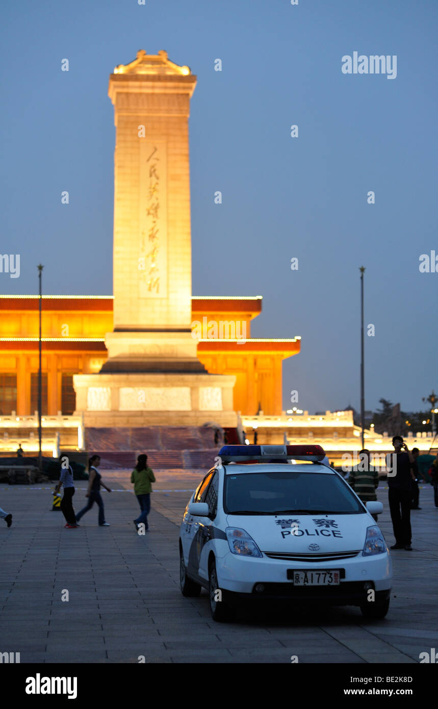 Voiture de police de la Place Tiananmen et les 38 mètres (125 pieds) de haut monument aux héros du peuple de Beijing, CN Banque D'Images