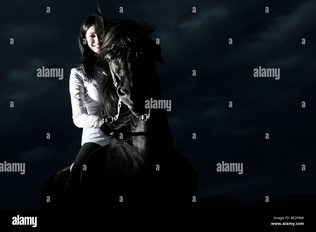 Jeune femme à cheval sur son cheval brun foncé Banque D'Images