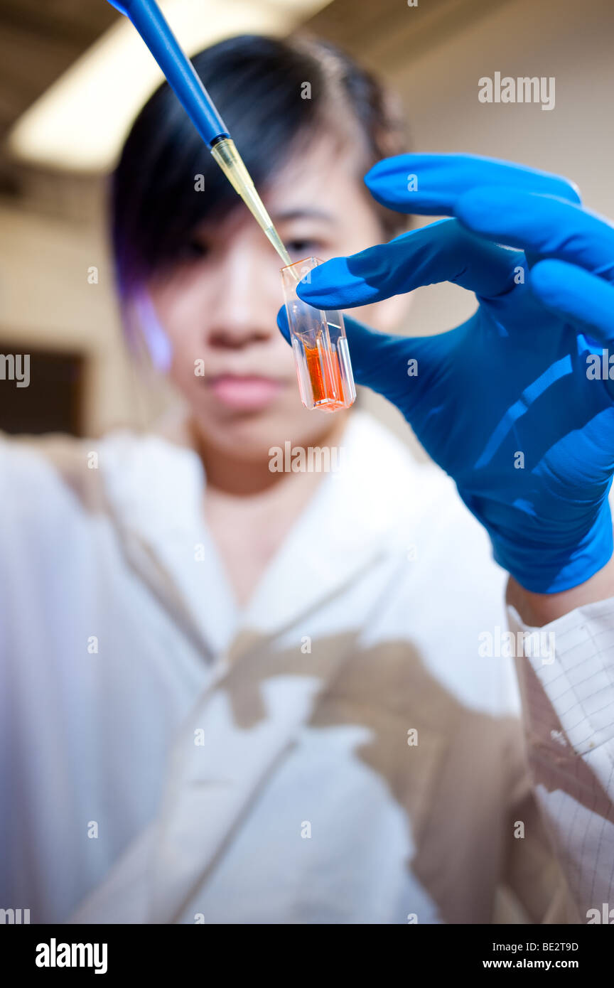 Un étudiant en science de sexe féminin dans un bécher solution transferts Banque D'Images