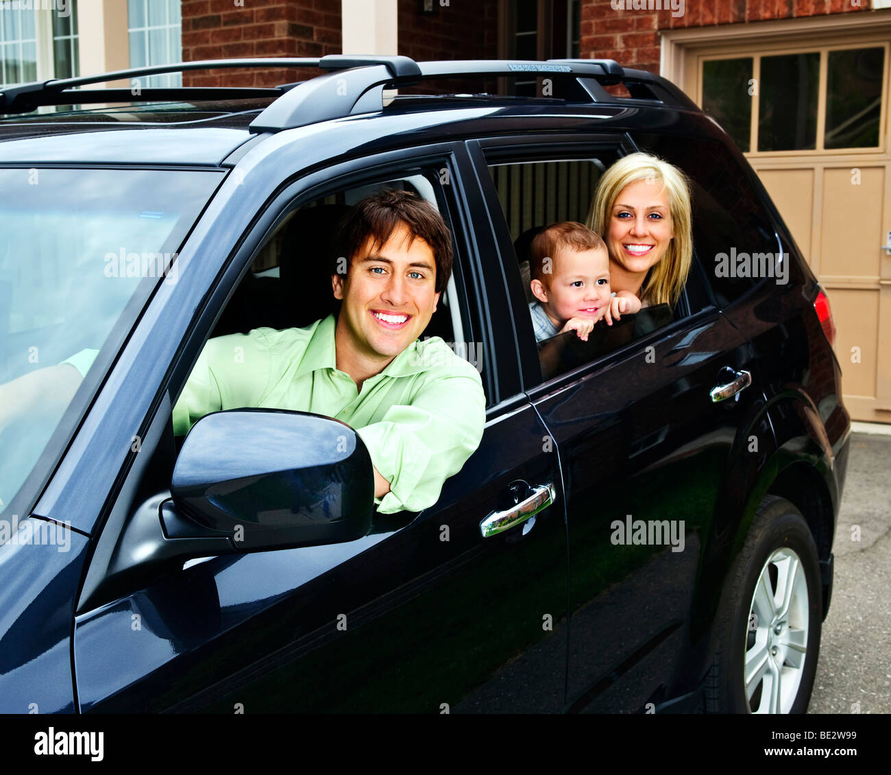 Happy Family sitting in black car à la recherche de windows Banque D'Images