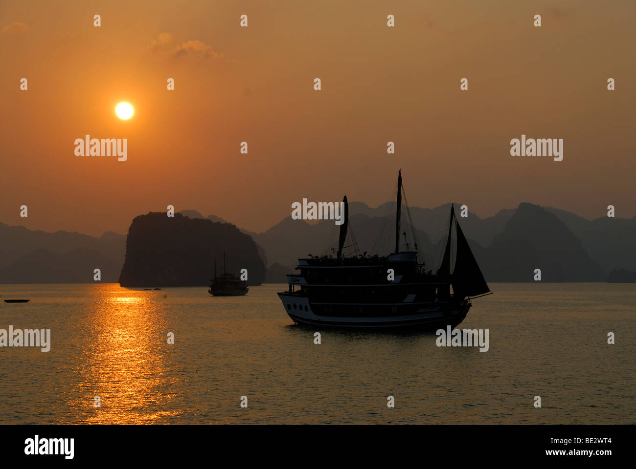 Silhouette d'un Junk au coucher du soleil en face de montagnes coniques, Ha Long Bay, Vietnam, Asie du Sud, Asie Banque D'Images