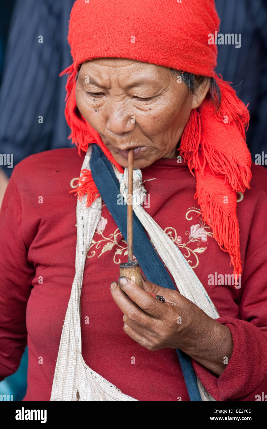 Hani femme Tribal fumant une pipe au marché de Menghun au Yunnan, Chine Banque D'Images