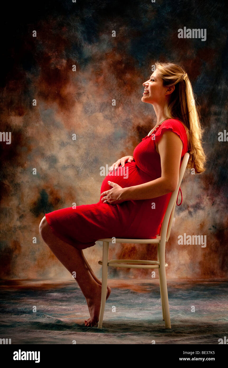 Pregnant woman sitting in chair Banque D'Images