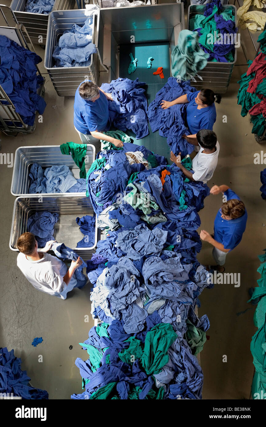 Vert et Bleu vêtements de l'hôpital d'être triés par type et couleur après avoir été lavés dans une blanchisserie industrielle, Textil-Mietdienst Banque D'Images