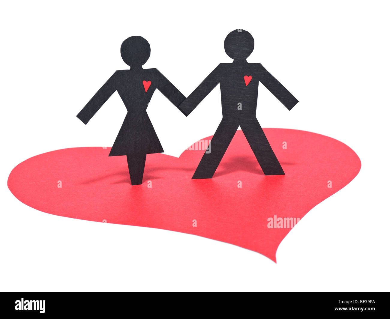 Un couple de personnages de papier se tenant la main sur un papier rouge coeur. Isolé sur blanc. Banque D'Images