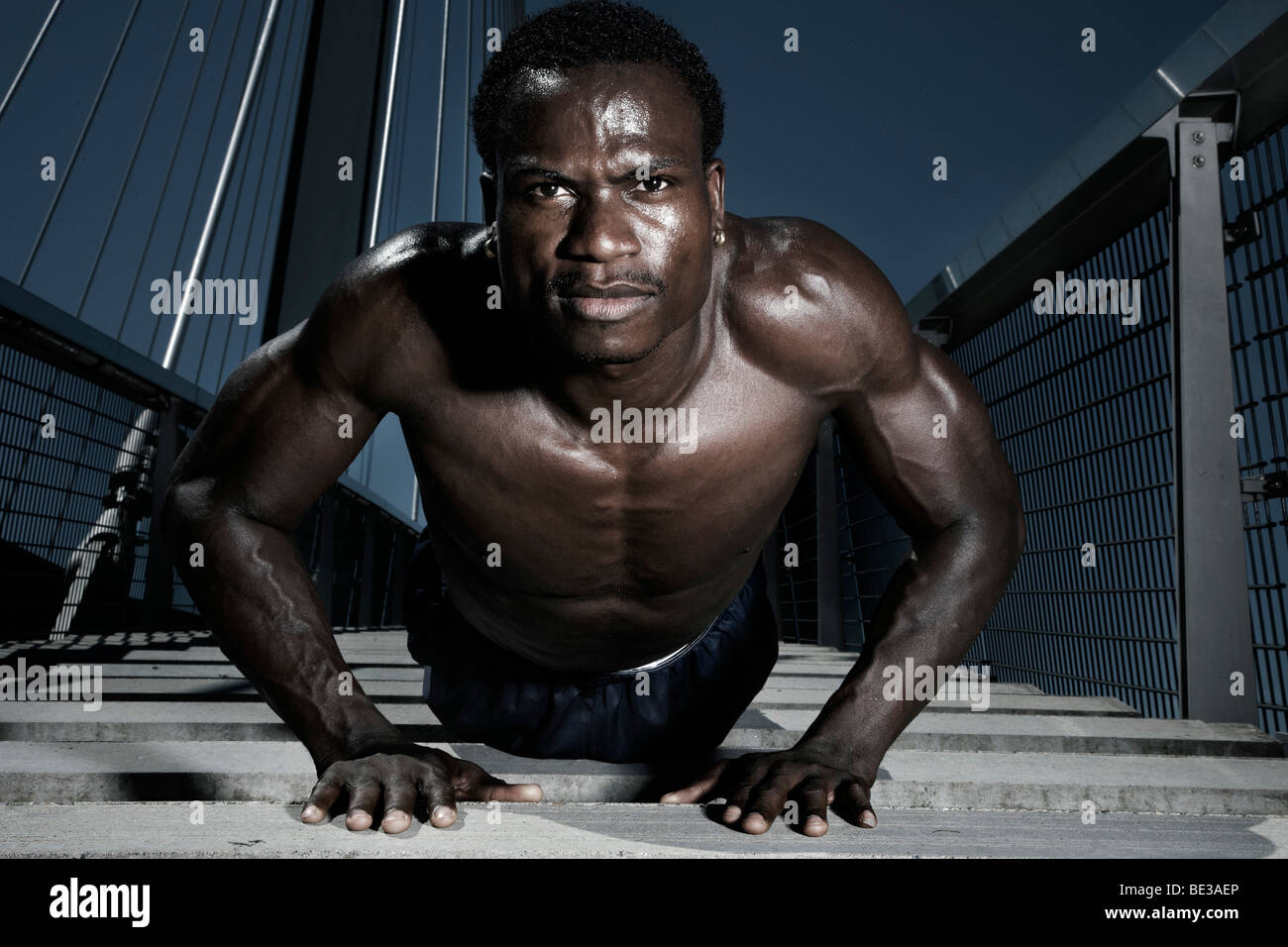 Jeune athlète à la peau sombre, faisant push-ups Banque D'Images