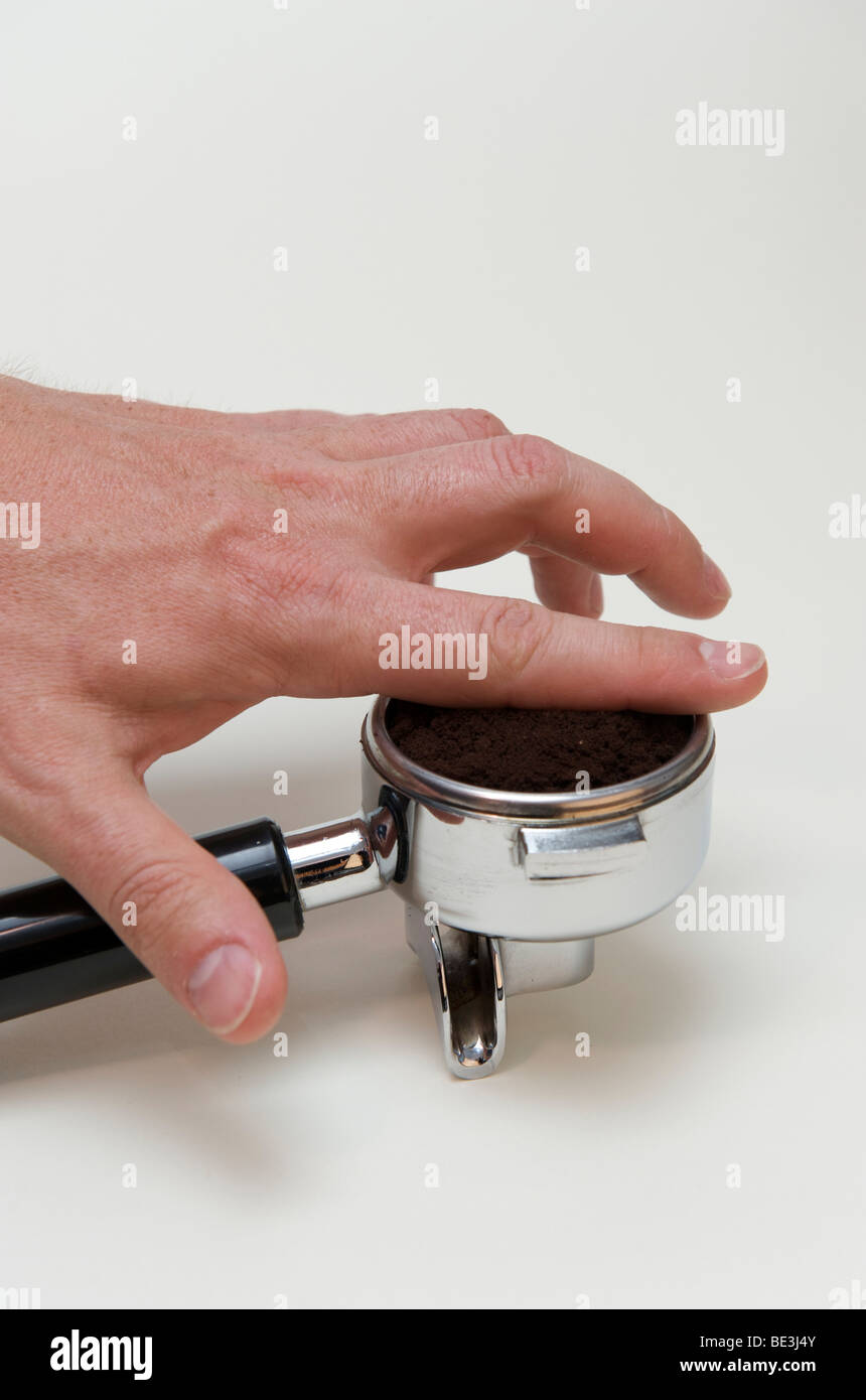 La préparation professionnelle de l'espresso avec une machine à expresso : distribution du café moulu de façon homogène dans le portafilter avec l'If Banque D'Images
