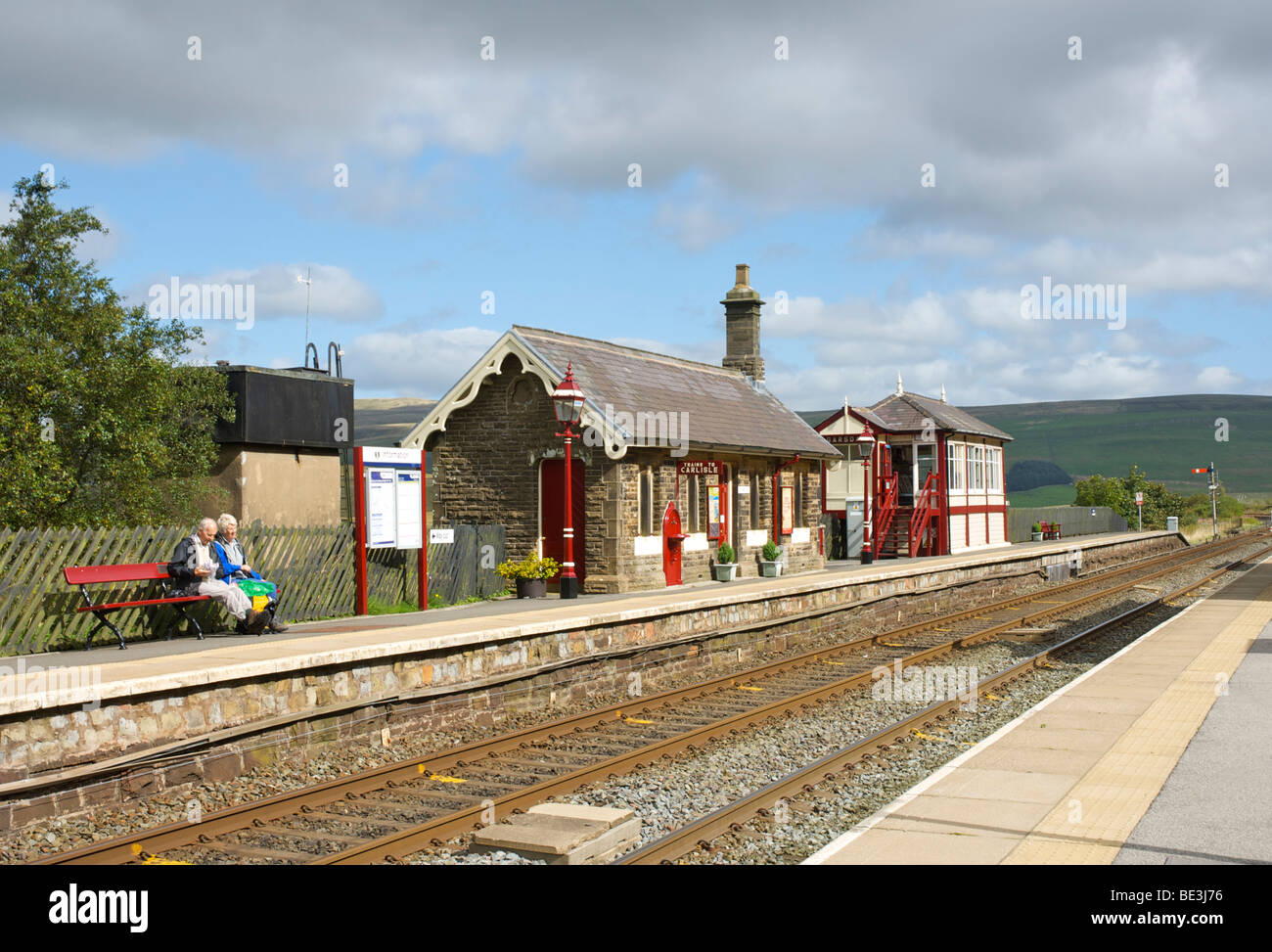 Couple assis sur un banc, Garsdale, sur la ligne de chemin de fer Settle-Carlisle, Yorkshire Dales National Park, England UK Banque D'Images
