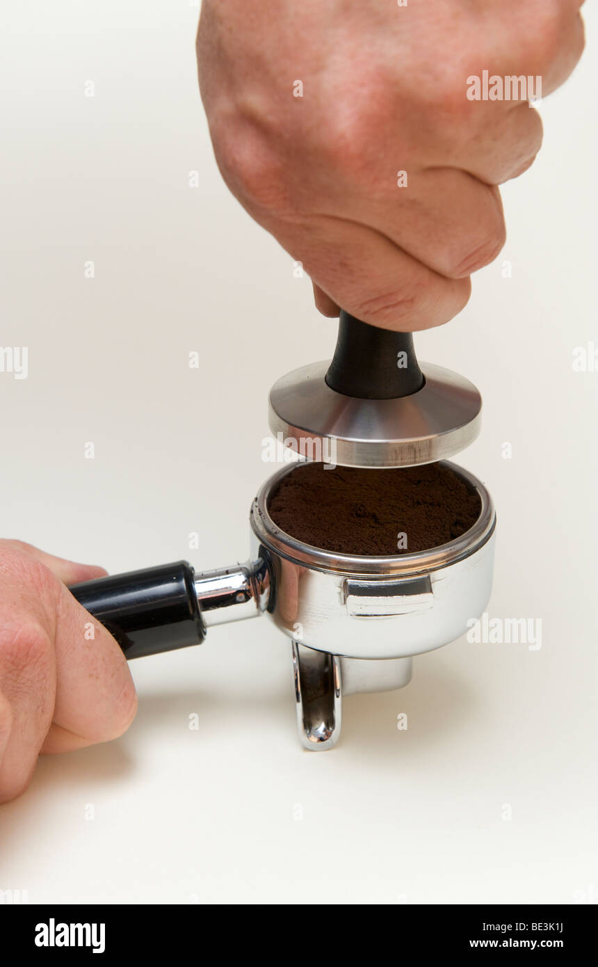 La préparation professionnelle de l'espresso avec une machine à expresso : Le toucher est soigneusement mis sur le café Banque D'Images
