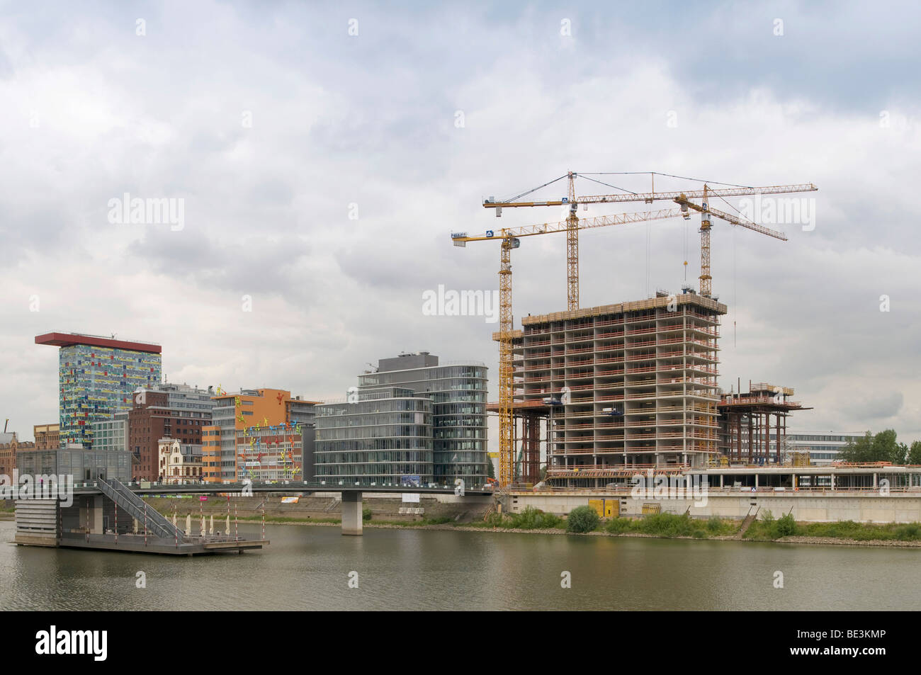 Grand site en construction media port Medienhafen de Düsseldorf, l'enveloppe du bâtiment de l'hôtel à côté d'immeubles de bureaux avec 'Flossis', l'K Banque D'Images
